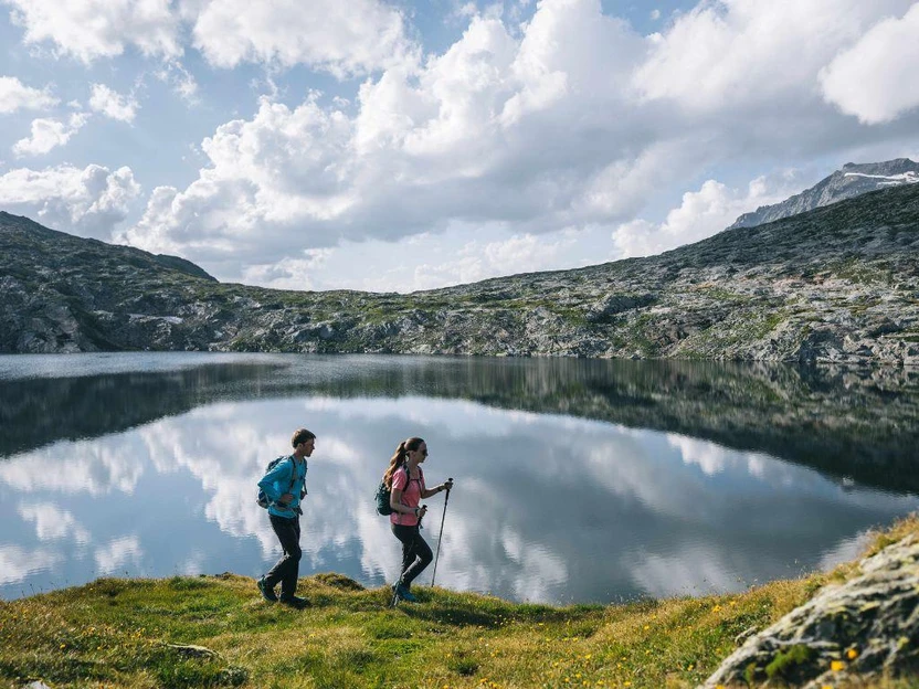 Wochenende im Tessin – Wanderpaar an einem Bergsee in der Leventina